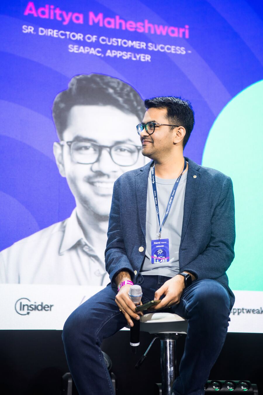 Aditya Maheshwari on stage, with his name and title on the screen behind him